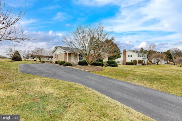 view of front of property featuring brick siding and a front yard