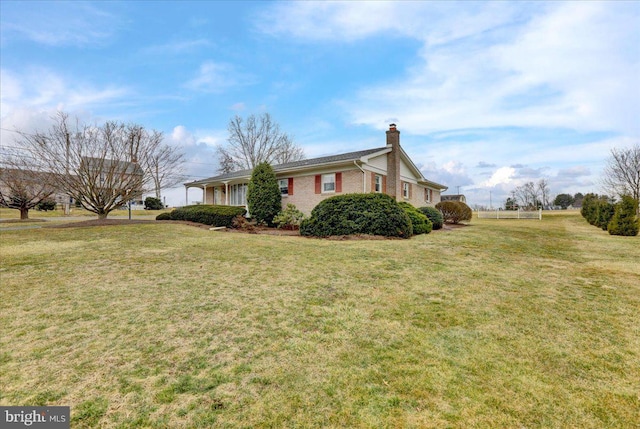 view of property exterior featuring a yard, brick siding, and a chimney