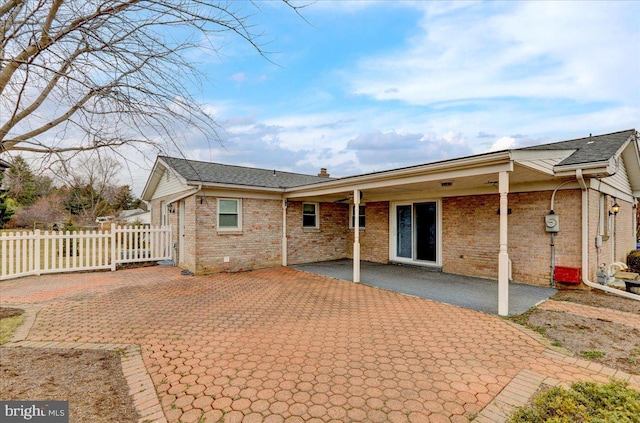 back of property featuring a patio area, fence, and brick siding