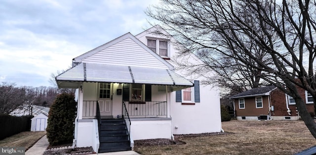 view of front of home featuring an outbuilding, covered porch, and stucco siding