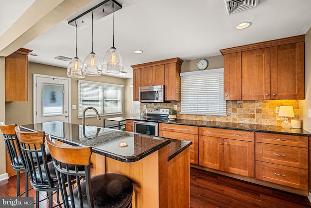 kitchen featuring appliances with stainless steel finishes, dark wood-style flooring, and visible vents