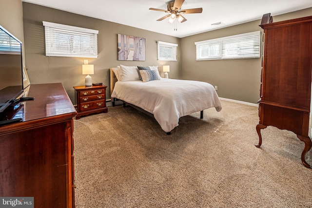 carpeted bedroom with a ceiling fan, visible vents, and baseboards