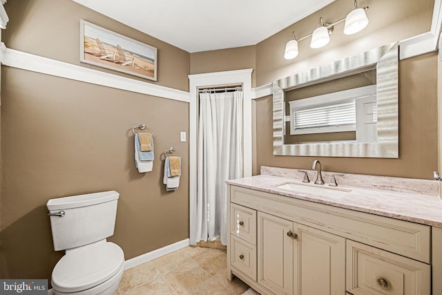 bathroom featuring curtained shower, toilet, vanity, tile patterned flooring, and baseboards