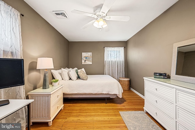 bedroom featuring light wood-type flooring, baseboards, visible vents, and ceiling fan