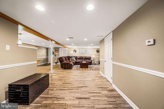 corridor with light wood-type flooring, visible vents, baseboards, and recessed lighting