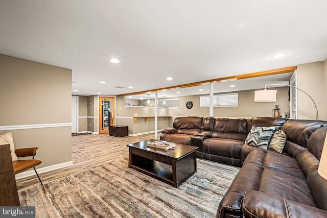 living area with baseboards, wood finished floors, and recessed lighting