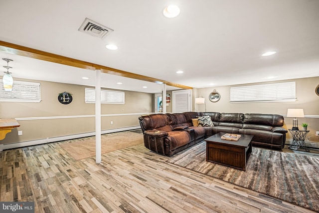 living area with a baseboard heating unit, recessed lighting, visible vents, and wood finished floors