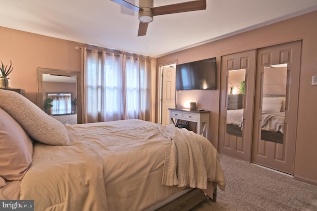 bedroom with carpet floors, ceiling fan, and multiple closets