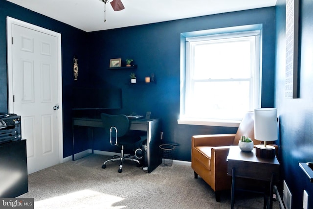 carpeted office space with baseboards and a ceiling fan