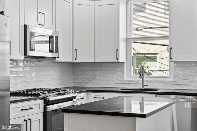 kitchen featuring white cabinetry, decorative backsplash, stainless steel appliances, and a sink