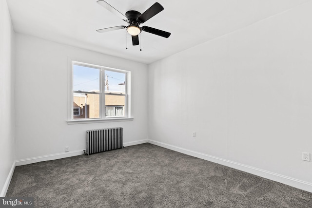 empty room with a ceiling fan, radiator, dark carpet, and baseboards