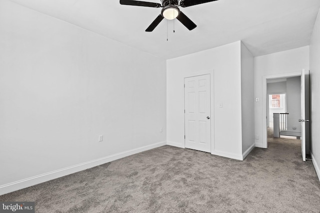 unfurnished bedroom with carpet, a ceiling fan, and baseboards