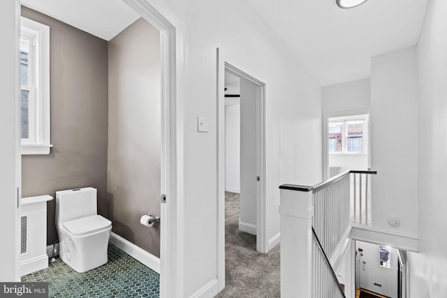 bathroom with toilet and baseboards