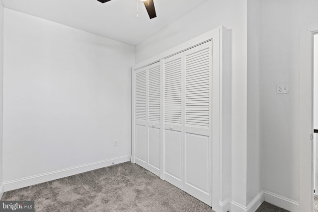 unfurnished bedroom with carpet floors, a closet, ceiling fan, and baseboards