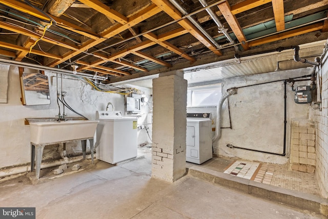 basement with electric panel, a sink, and washer and clothes dryer