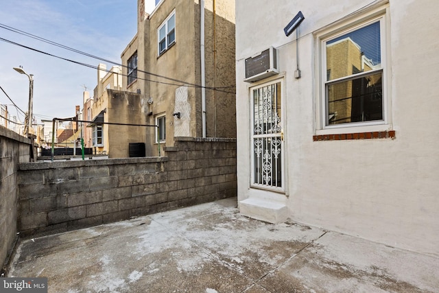 view of side of property featuring fence, an AC wall unit, and stucco siding