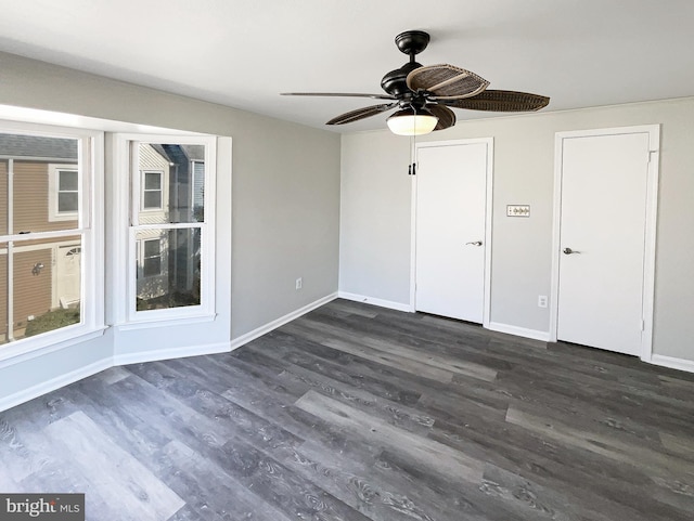 unfurnished bedroom with ceiling fan, baseboards, and dark wood-type flooring