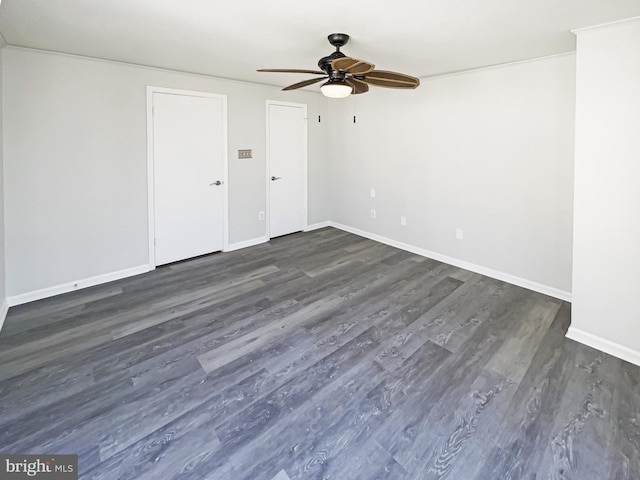 empty room with a ceiling fan, dark wood-style flooring, and baseboards