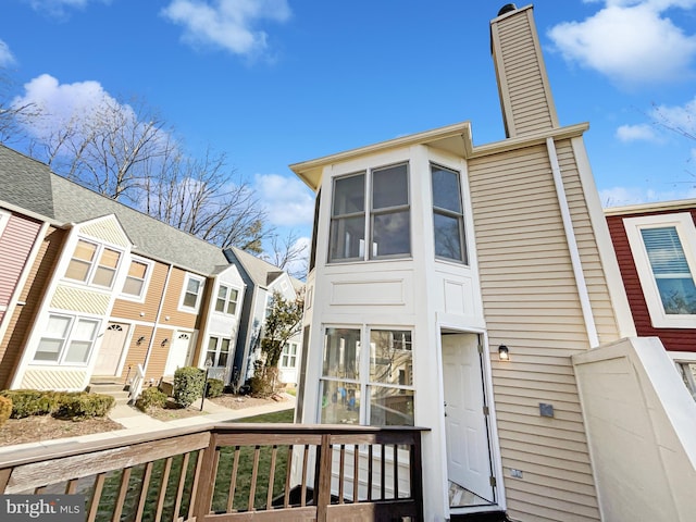 exterior space featuring a chimney and a residential view