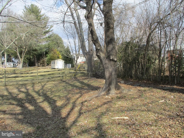 view of yard with a storage unit, an outdoor structure, and fence