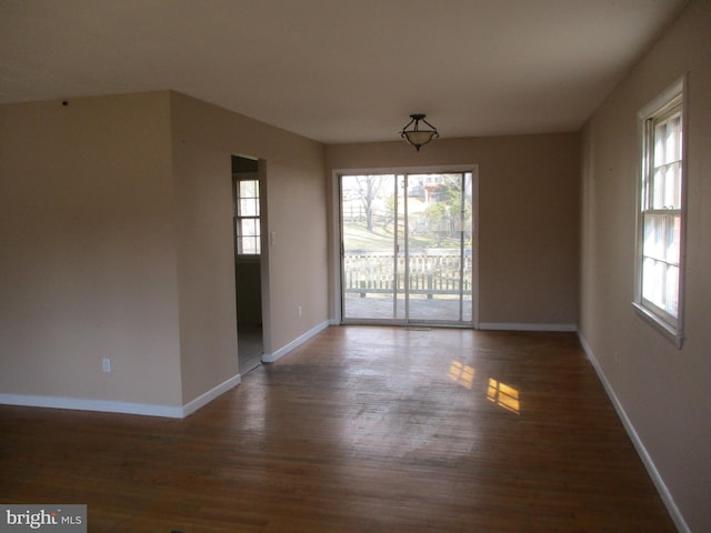 unfurnished room with baseboards and wood finished floors