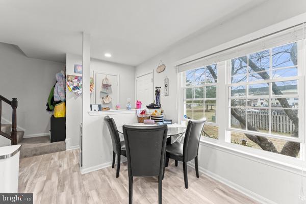 dining space with light wood finished floors, baseboards, stairway, and recessed lighting