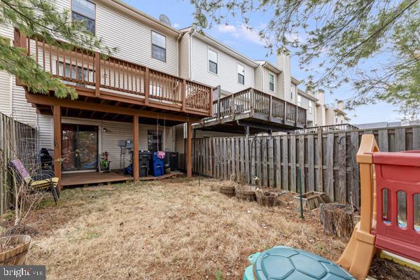 back of house with a deck and a fenced backyard