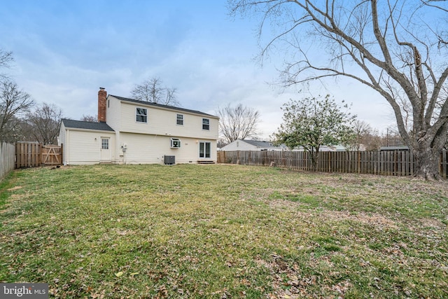 rear view of property with cooling unit, a fenced backyard, a lawn, and a chimney