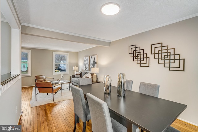 dining area featuring crown molding, a textured ceiling, and hardwood / wood-style flooring