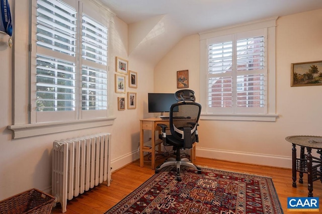 home office with radiator heating unit, wood finished floors, and baseboards