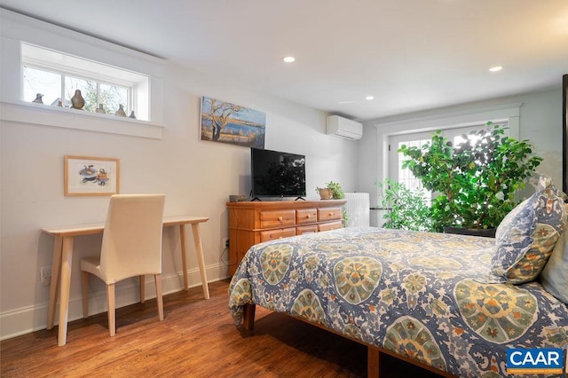 bedroom with recessed lighting, an AC wall unit, multiple windows, and wood finished floors