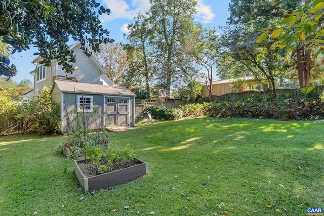 view of yard with an outbuilding, a vegetable garden, fence, and a shed