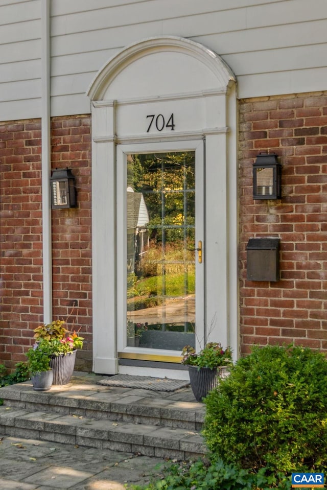 entrance to property featuring brick siding