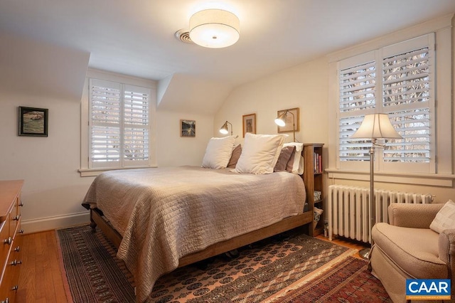 bedroom featuring radiator, wood-type flooring, and baseboards