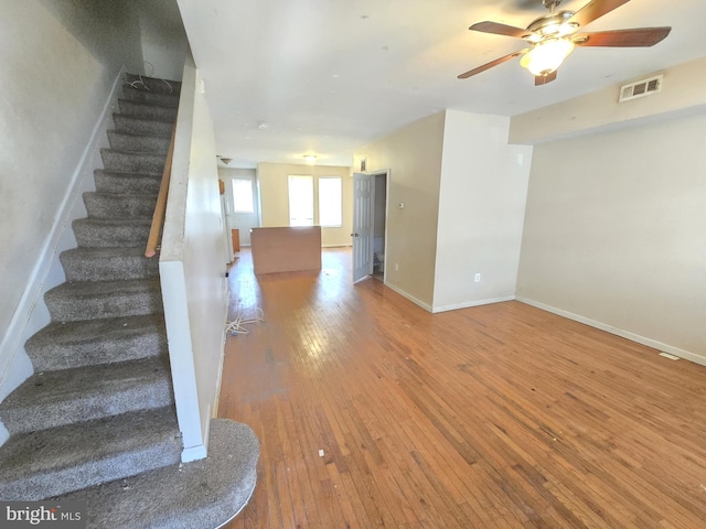 interior space featuring a ceiling fan, hardwood / wood-style flooring, visible vents, and baseboards