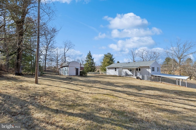 view of yard featuring an outdoor structure and fence