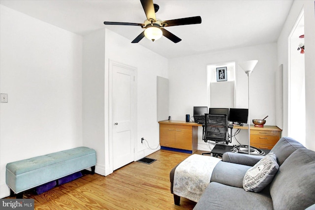 office area with light wood finished floors, ceiling fan, and visible vents