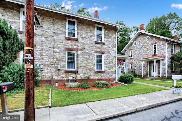 view of front of house featuring a front yard and a chimney