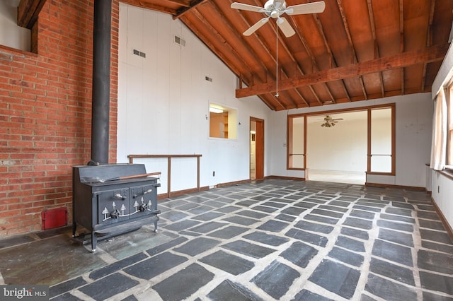 unfurnished living room with a wood stove, visible vents, ceiling fan, and wooden ceiling