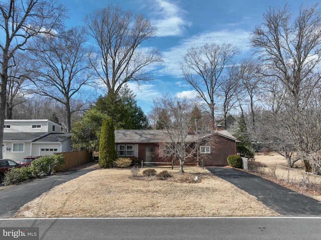 view of front of home featuring driveway and fence