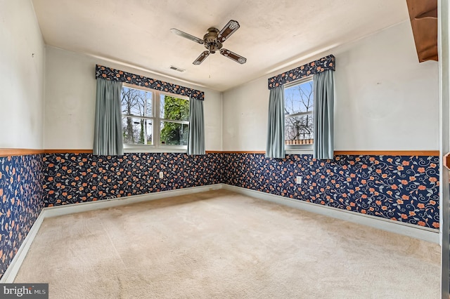 spare room with a healthy amount of sunlight, carpet flooring, and wallpapered walls