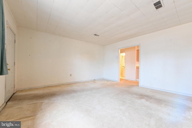 unfurnished room featuring baseboards and visible vents