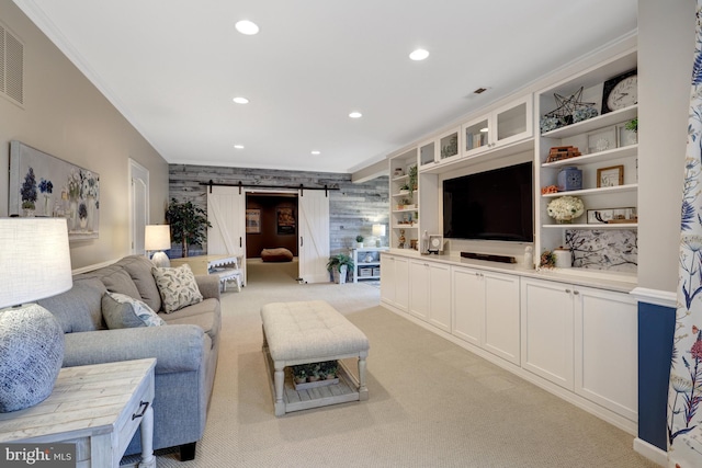 living area featuring visible vents, recessed lighting, a barn door, crown molding, and light colored carpet