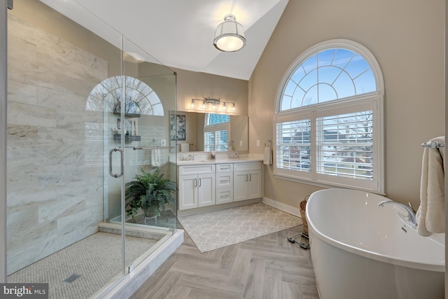 bathroom with vanity, baseboards, lofted ceiling, a freestanding bath, and a shower stall