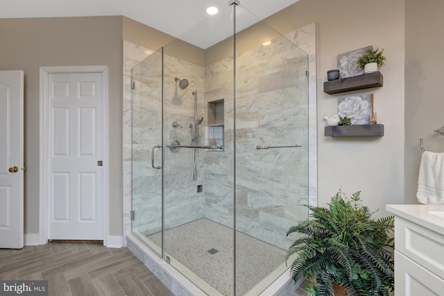 full bathroom with a stall shower, vanity, and baseboards