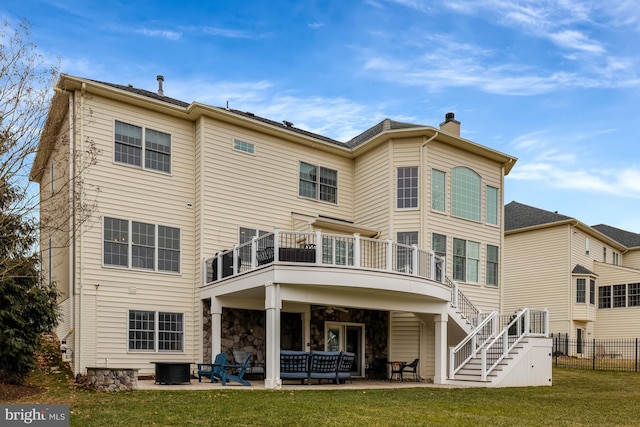 back of house with fence, stairs, a lawn, a chimney, and a patio