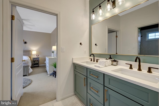 full bath with double vanity, ensuite bath, a ceiling fan, and a sink