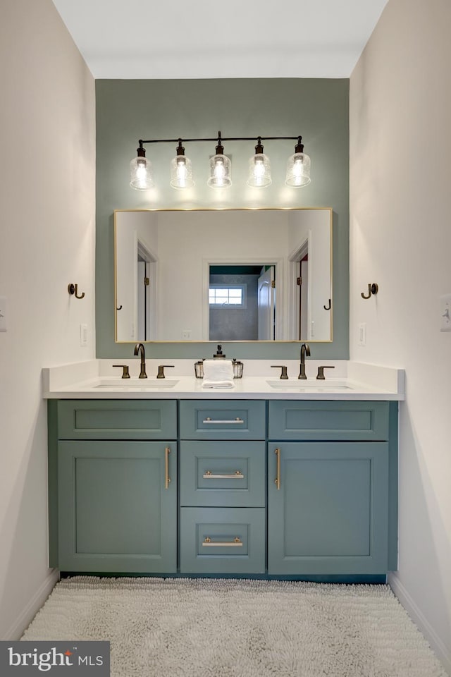 full bathroom featuring a sink, baseboards, and double vanity