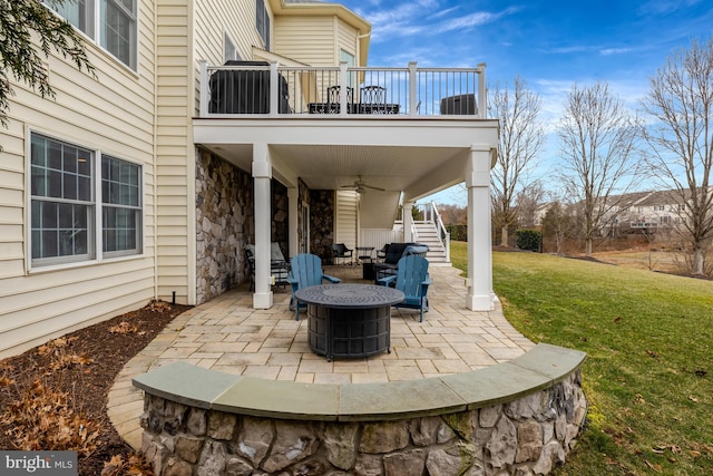 view of patio with central AC, an outdoor fire pit, stairway, a balcony, and ceiling fan