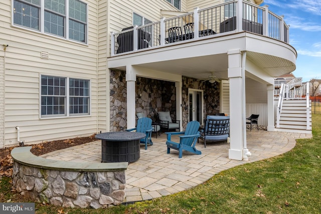 view of patio / terrace with stairway, a fire pit, and a balcony